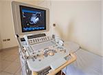 Examination bed with ultrasound scanner machine in medical center hospital