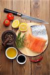 Salmon, spices and condiments on wooden table. Top view