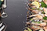 Fresh prawns with spices and white wine on black stone background. Top view with copy space