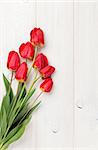 Red tulips bouquet over white wooden table background with copy space