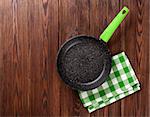 Frying pan on wooden table. Top view with copy space