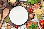 Pasta cooking ingredients and utensils on wooden table. Top view with empty plate for copy space