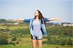 Beautiful young woman feeling the summer breeze and enjoying the vacations