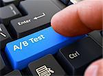 AB Test - Written on Blue Keyboard Key. Male Hand Presses Button on Black PC Keyboard. Closeup View. Blurred Background.