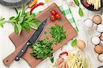 Pasta cooking ingredients and utensils on wooden table. Top view