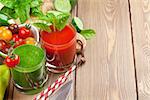Fresh vegetable smoothie on wooden table. Tomato and cucumber. View with copy space