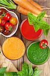 Fresh vegetable smoothie on wooden table. Tomato, cucumber, carrot. Top view