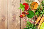 Fresh vegetable smoothie on wooden table. Tomato, cucumber, carrot. Top view with copy space