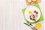 Healthy breakfast with fried egg, toasts and salad on white wooden table. Top view with copy space
