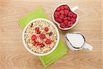 Healty breakfast with muesli, berries and milk on wooden table