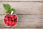 Fresh ripe raspberries bowl on wooden table background with copy space