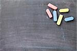 Colorful chalk on blackboard background. Top view with copy space