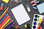 School and office supplies on blackboard background. Top view with copy space