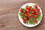 Cherry tomatoes plate on wooden table. Top view with copy space