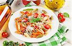 Colorful penne pasta and white wine on wooden table