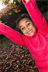 Portrait photograph of a beautiful young smiling happy mixed race interracial African American girl, playing outside in a park