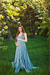 Young beautiful pregnant girl with long brown hair in blue dress