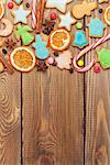 Christmas wooden background with candies, spices, gingerbread cookies and copy space