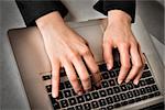 Closeup of hands of a business woman typing on a laptop