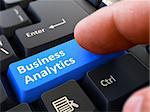 Business Analytics Button. Male Finger Clicks on Blue Button on Black Keyboard. Closeup View. Blurred Background.