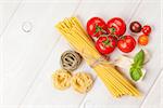 Italian food cooking ingredients. Pasta, tomatoes, basil. Top view with copy space