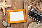 Travel and vacation photo frame and items on wooden table. Top view