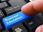 Business Education - Written on Blue Keyboard Key. Male Hand Presses Button on Black PC Keyboard. Closeup View. Blurred Background.