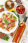 Colorful penne pasta and white wine on wooden table. Top view