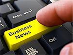 Business News - Written on Yellow Keyboard Key. Male Hand Presses Button on Black PC Keyboard. Closeup View. Blurred Background.