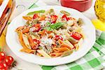 Colorful penne pasta and white wine on wooden table