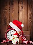 Christmas gift box, alarm clock and snowman toy. View with copy space