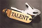 Keys and Golden Keyring with the Word Talent over Black Wooden Table with Blur Effect. Toned Image.