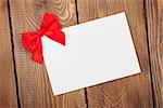 Valentines day greeting card with red bow over wooden background