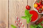 Fresh tomato juice smoothie with basil on wooden table. Top view with copy space