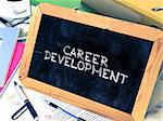 Career Development Handwritten by white Chalk on a Blackboard. Composition with Small Chalkboard on Background of Working Table with Office Folders, Stationery, Reports. Blurred Background. Toned Image.