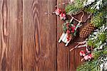 Christmas wooden background with snow fir tree and holly berry