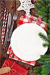 Christmas table setting with gift box and fir tree on wooden table. Top view
