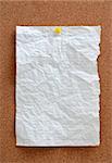 Blank piece paper pinned into brown corkboard