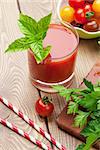 Fresh tomato juice smoothie with basil on wooden table