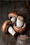 Brown champignon mushrooms with on old wooden table