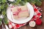 Christmas table setting with gift box and fir tree on wooden table