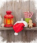 Christmas candle lantern and decor in front of wooden wall