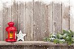 Christmas candle lantern and decor in front of wooden wall with copy space