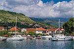 Small yacht marina with sailing boats landscape, mountain range and clouds background. Tivat, Montenegro