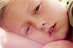 Close up portrait of boy lying down looking at camera