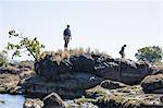 Couple exploring on rocks, near Victoria Falls, Zambia