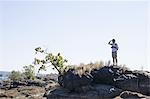 Mid adult man looking out from rocks, near Victoria Falls, Zambia