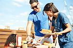 Mid adult woman selecting food at rooftop party