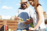 Couple eating and talking at rooftop party