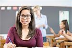 Portrait of female student, sitting at desk in classroom